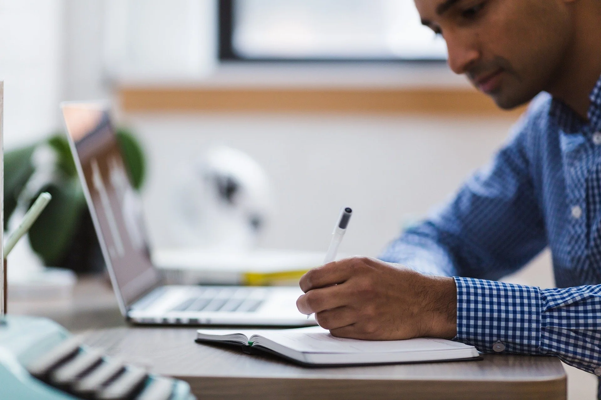 A man writing a note at his work desk